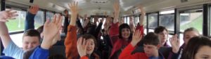 students in the bus waving