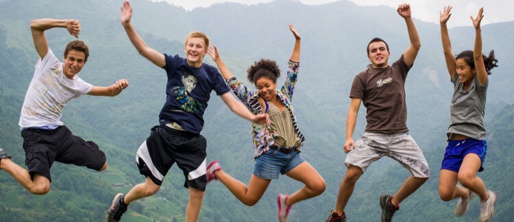 five excited students jumping of joy